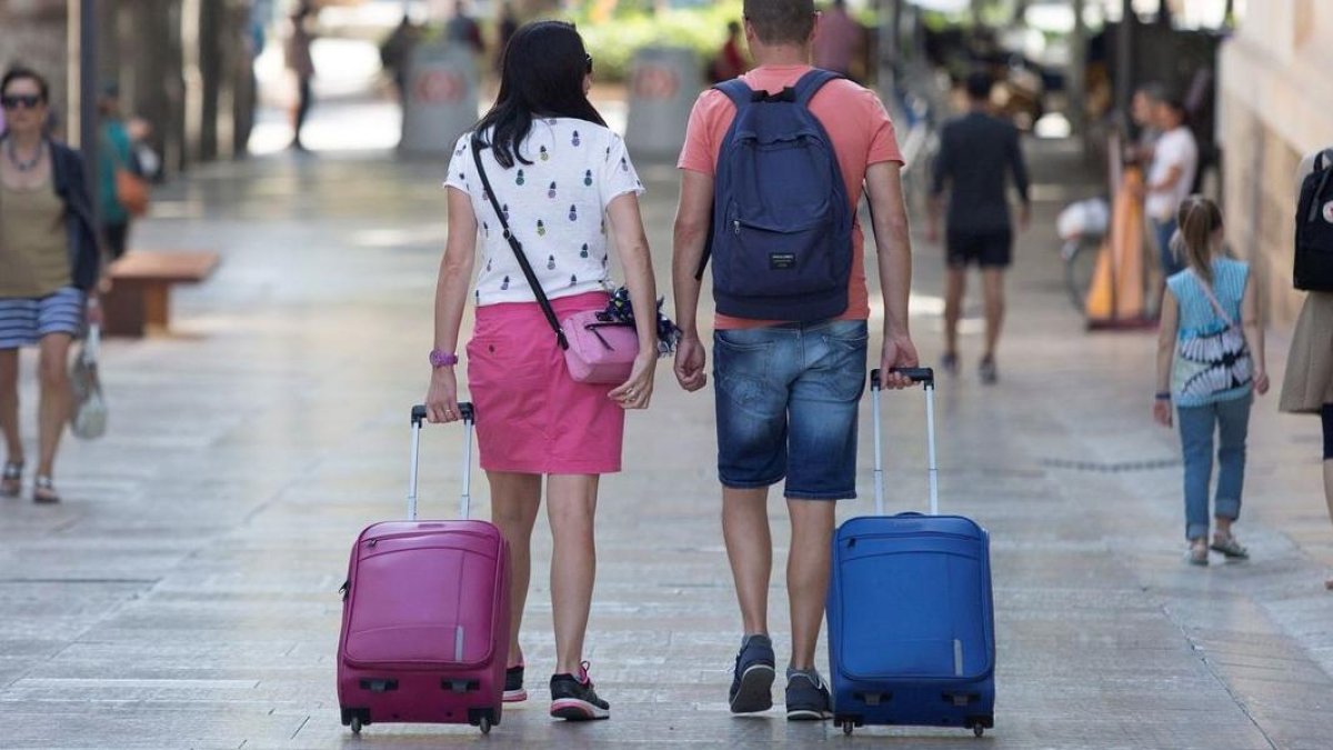 Imatge d’arxiu de turistes amb maletes.