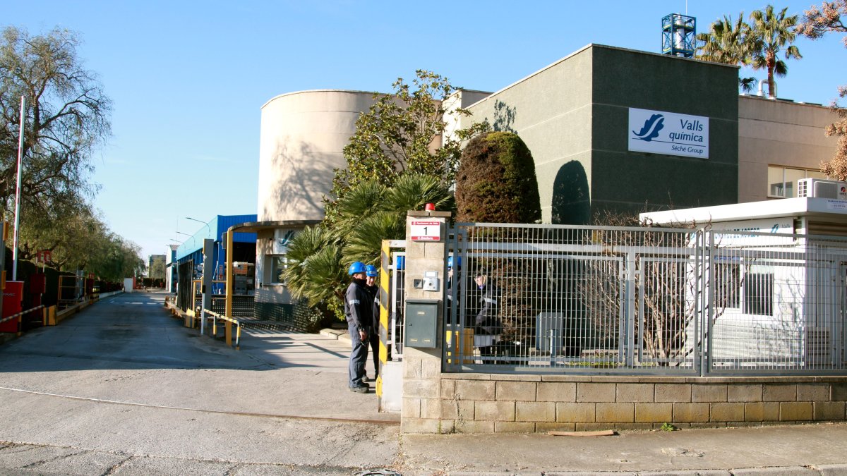 Empleados en la puerta de la empresa Valls Química, situada en el polígono de Valls, el día siguiente al incendio.