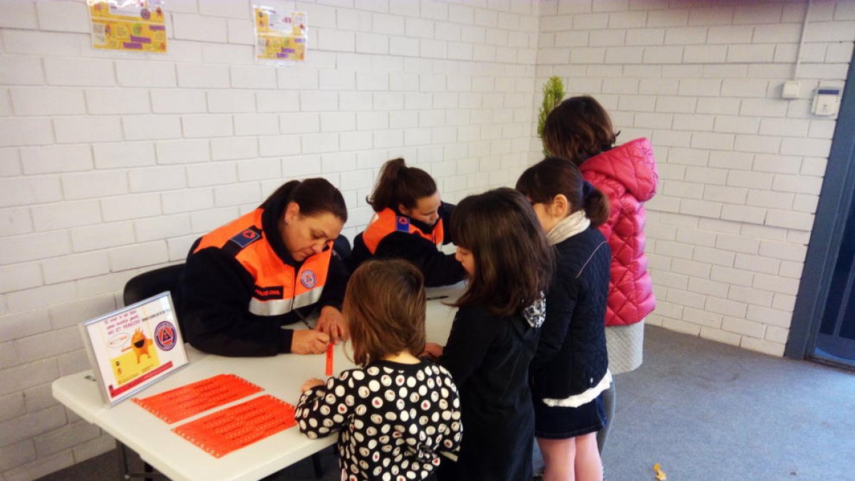 Protecció Civil i l'Ajuntament reparteixen polseres identificatives