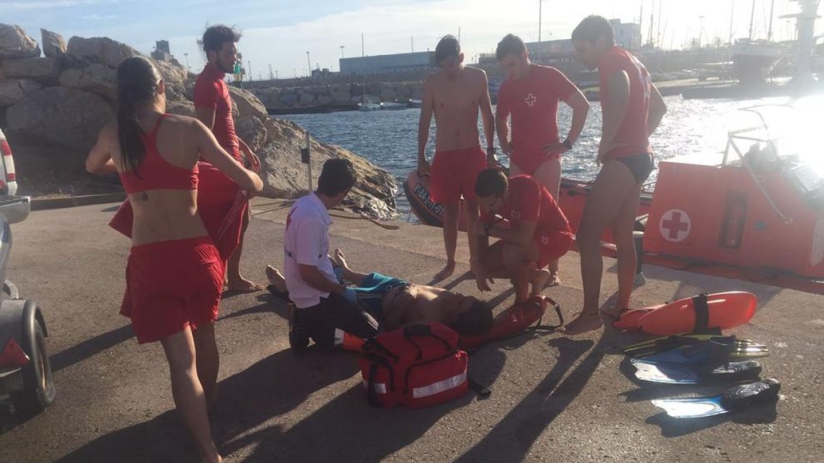 Un grup de socorristes fora de servei rescaten a un home a les roques de la platja del Miracle