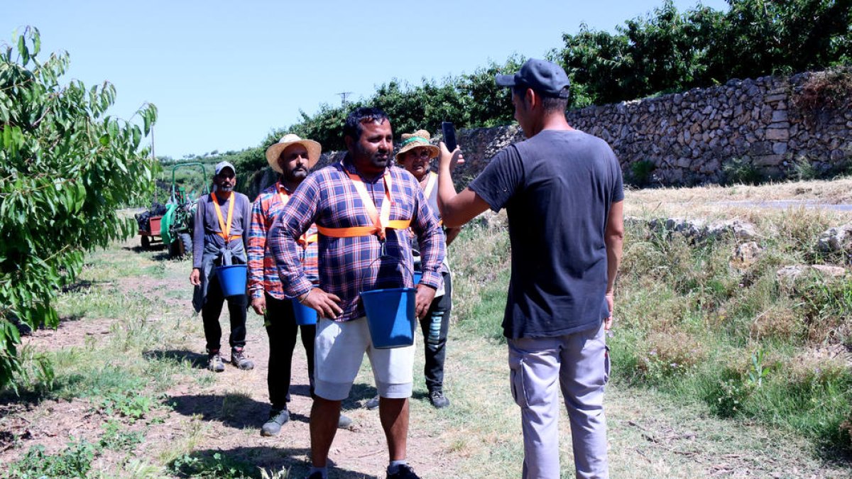 Cua de treballadors de camp de Cerima Cherries esperant per fitxar abans de començar a collir cireres.