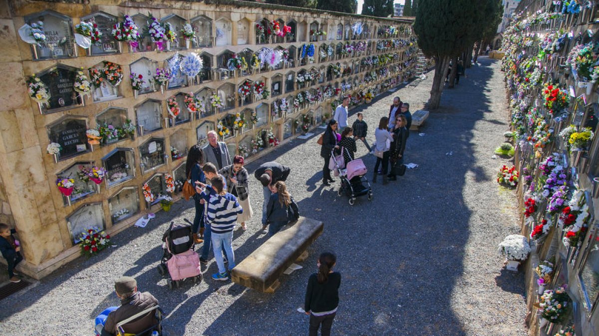 Familiars i amics omplen de flors el cementiri per recordar els seus difunts