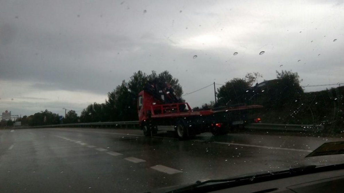 Un coche sube al margen de la carretera a causa de las lluvias
