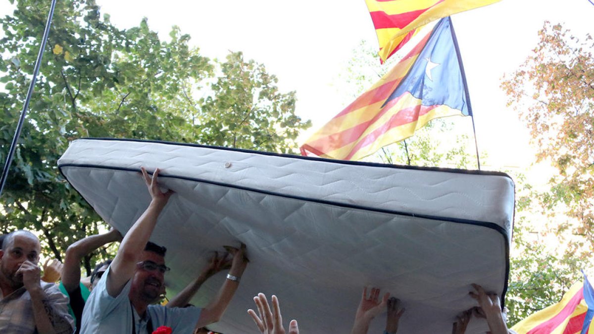 Voluntarios de l'ANC forman un pasillo para pacificar la salida de la Guardia Civil del Departamento de Economía