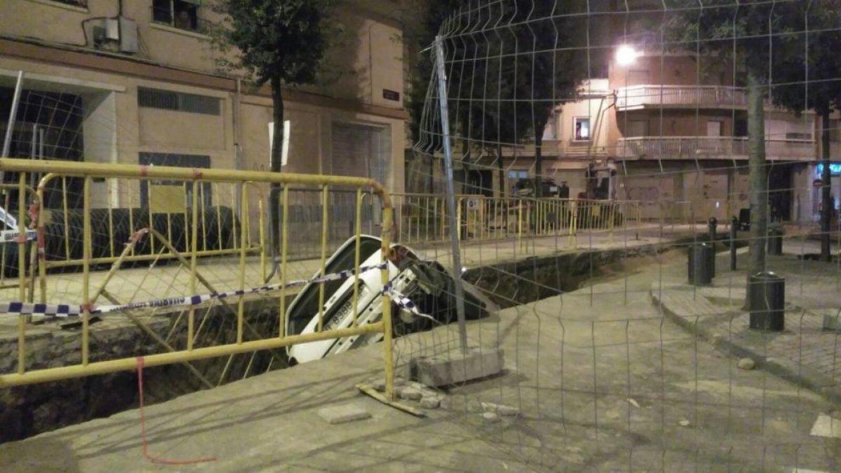Un cotxe cau i queda atrapat al forat d'unes obres a Reus