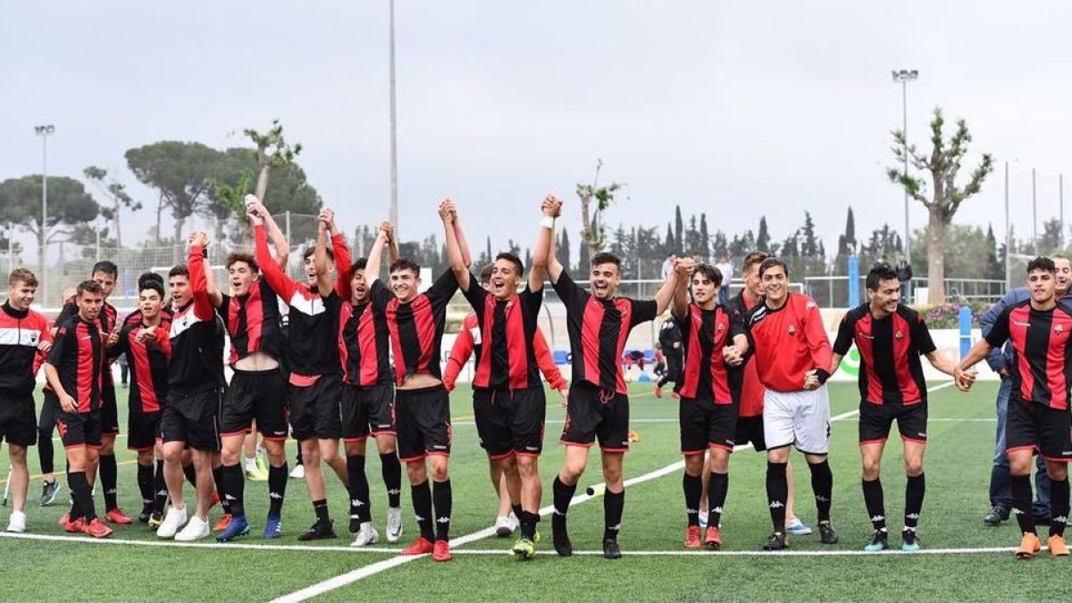 Els jugadors roig-i-negres celebrant l'ascens