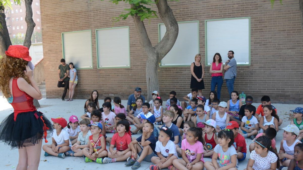 Varios niños en el casal del CEIP el Serrallo con la concejala Carla Aguilar al fondo.