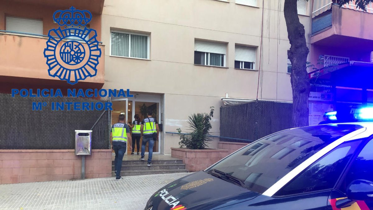 Imagen de agentes de la Policía Nacional actuando en el piso en cuestión, situado en la calle Josep Roqué i Tarragó.