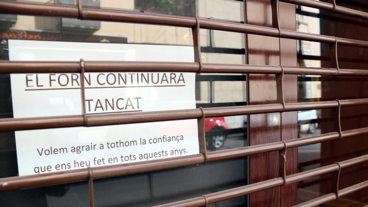 Pla detall del forn de pa Batet de Reus, una fleca artesana que ha baixat la persiana definitivament, amb un cartell informant els clients del seu tancament. Imatge publicada el 21 de novembre del 2018