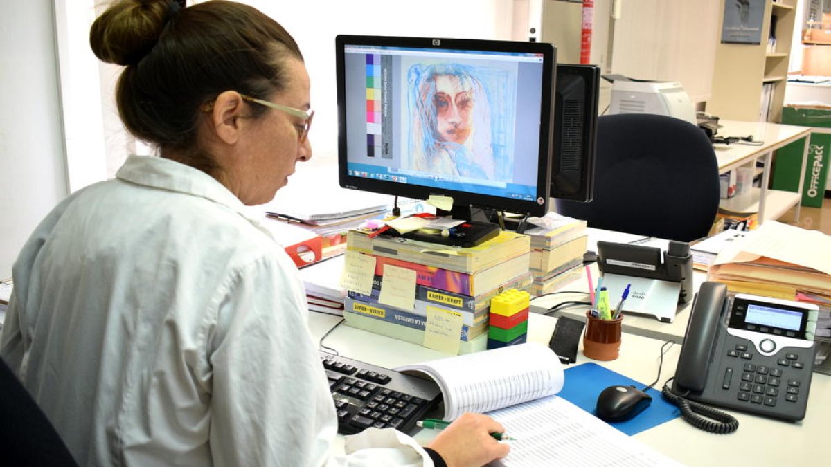 Una técnica de la Unidad de Conservación y Restauración de la Escola d'Art de la Diptuació trabajando en la catalogación e inventario de la obra de Robert Anglada.