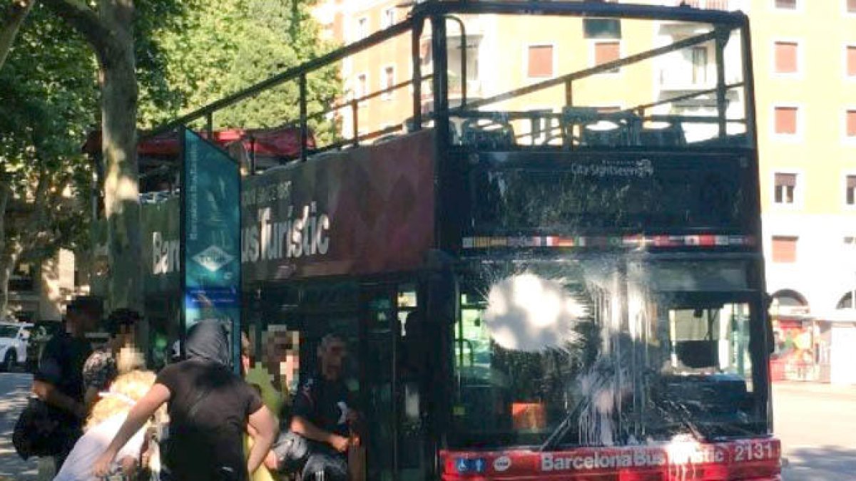 Dos encaputxats llencen pintura contra un bus turístic a la plaça Kennedy de Barcelona