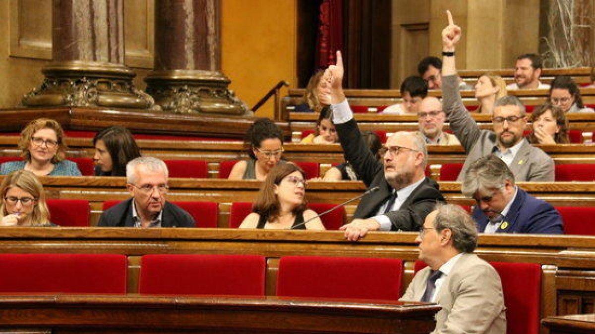 Eduard Pujol (JxCat) y Bernat Solé (ERC) votan afirmativamente durante el pleno del Parlament.