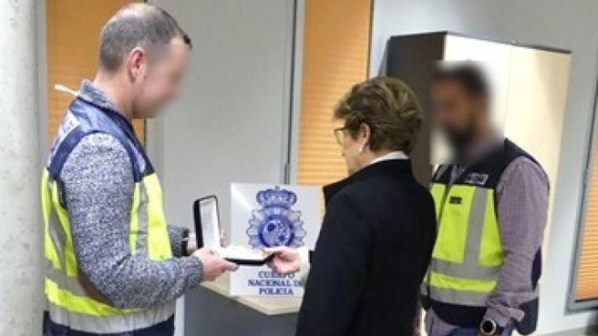 La policia retornant les joies robades a la seva propietària.