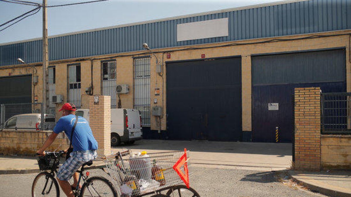 Un hombre pasa en una bicicleta cerca de la fábrica Magrudis en Sevilla, foco del brote de listeriosis.