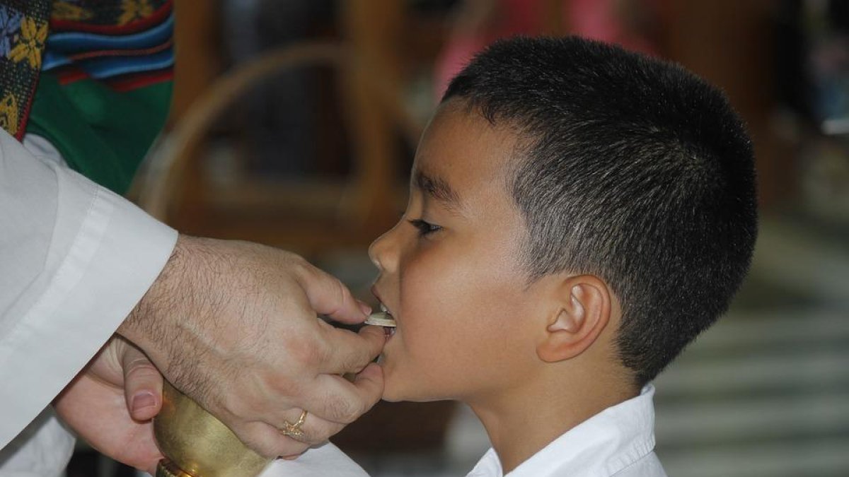 Un niño mujer el dinero recaudado durante su comunión a niños con cáncer