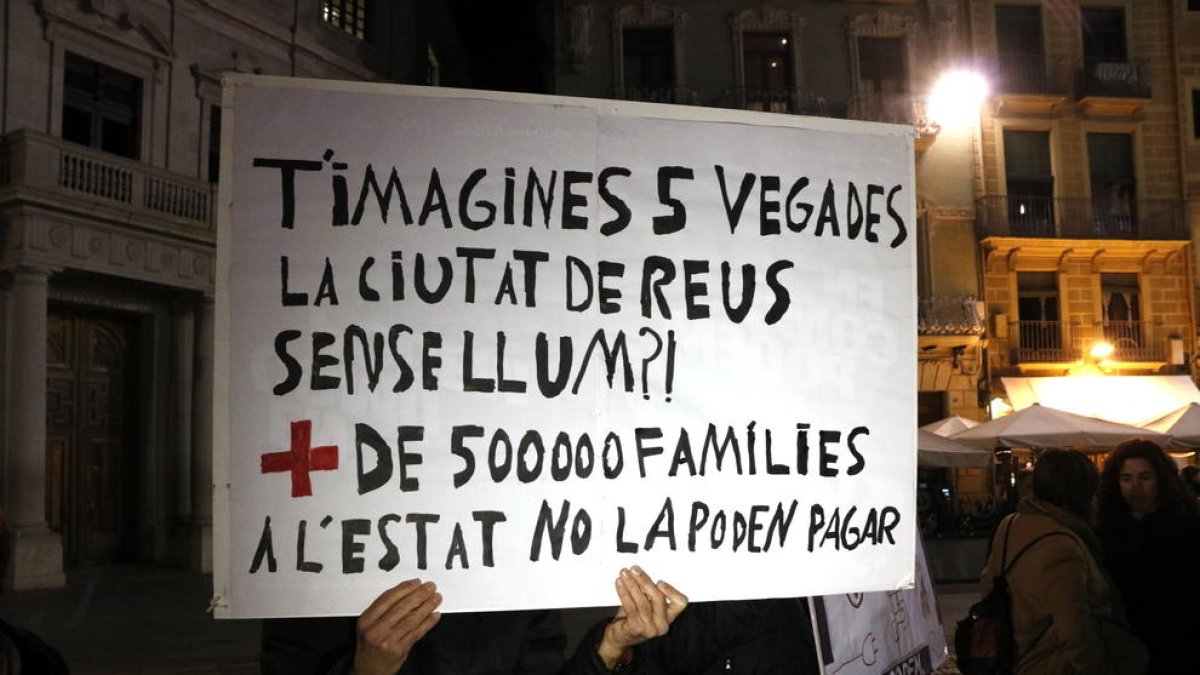 Un cartell que denuncia l'elevat nombre de llars que no poden pagar la factura de la llum.