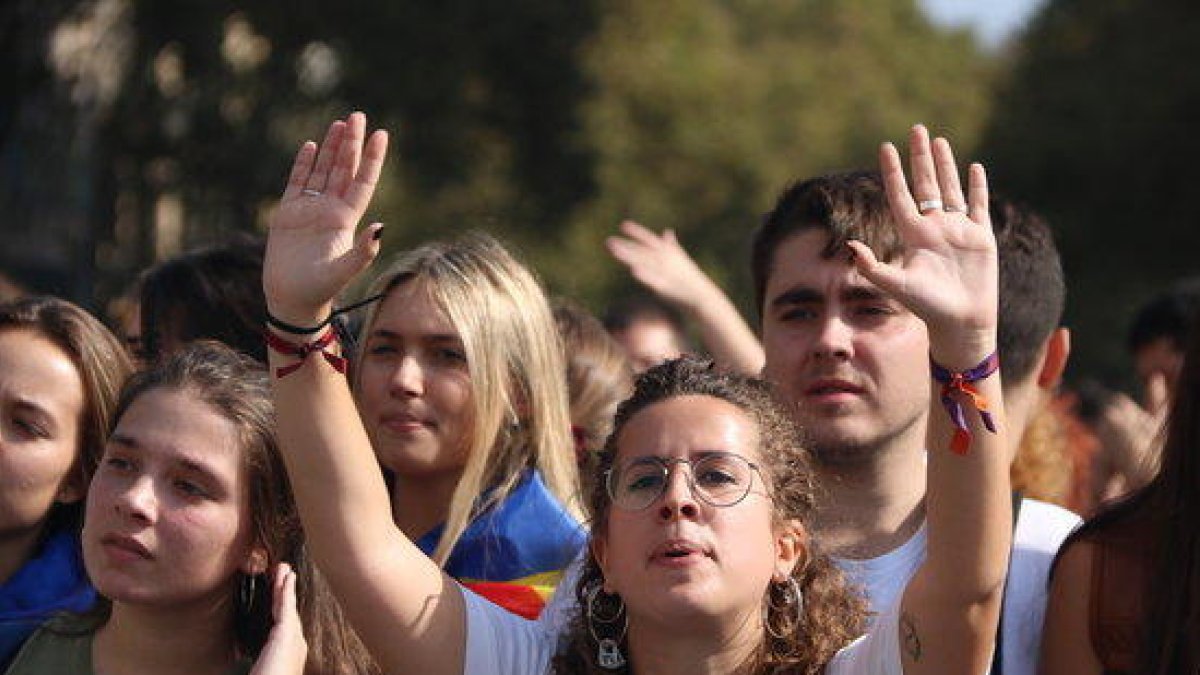 Primer plano de una chica con las manos levantadas durante la manifestación de estudiantes del 14 de octubre.