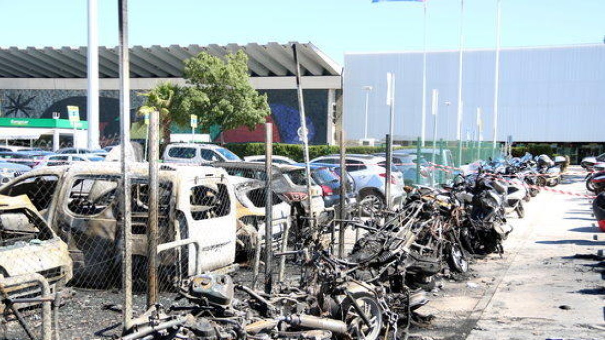 Las motos y los vehículos calcinados por el incendio en el aparcamiento de la T2 del Aeropuerto del Prat.