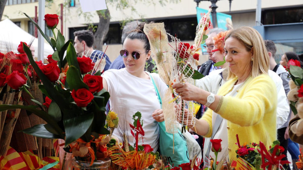 Image de dues dones comprant roses Durant la Diada de Sant Jordi 2018 a la Rambla Nova de Tarragona.