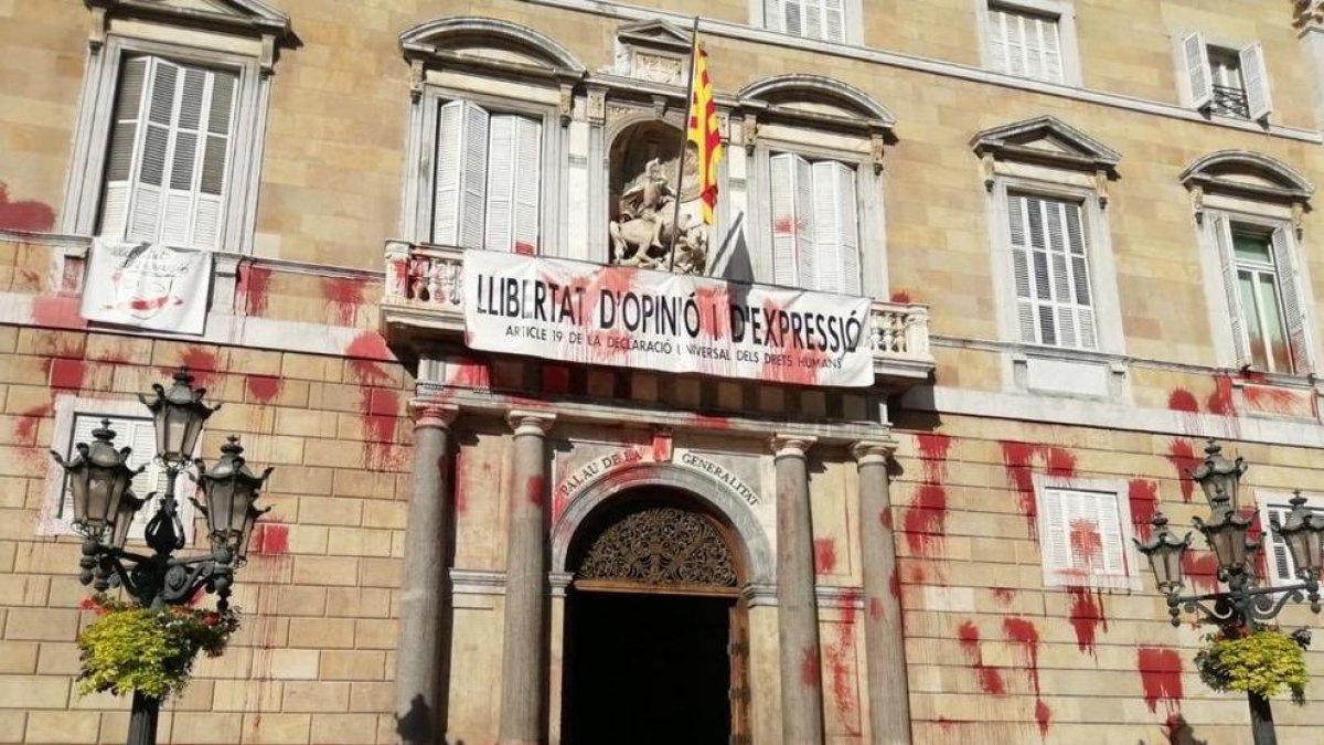 Una decena de personas tira pintura en la fachada de la Generalitat contra el cierre de la restauración
