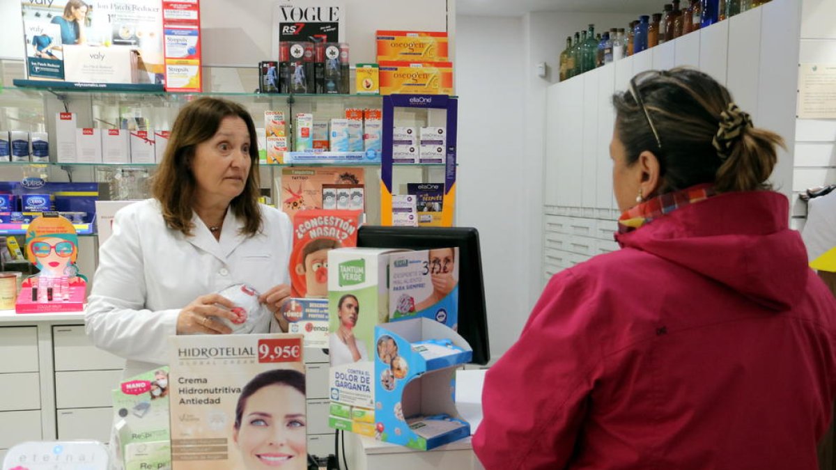 La responsable de la farmàcia Noguera de Girona ensenyant les mascaretes que els queden als compradors.