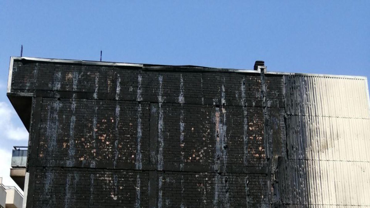 Un incendio en un solar del Vendrell se propaga afectando un edificio y tres vehículos