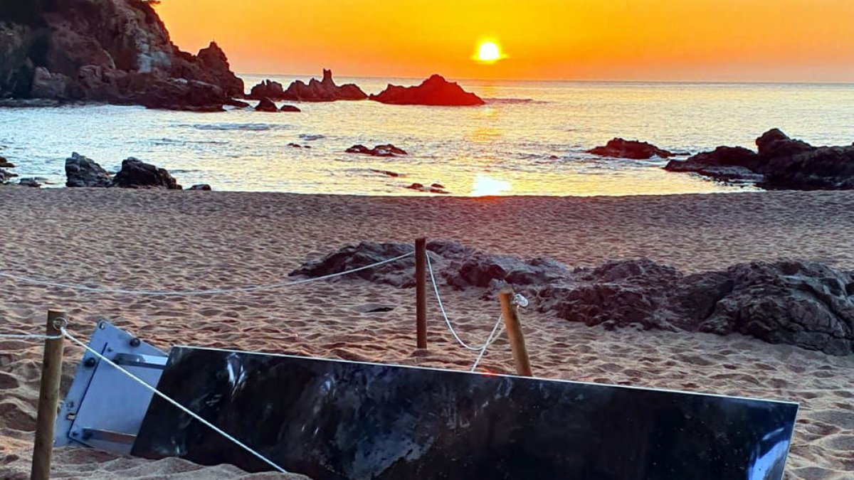 Un grup de joves tomba el monòlit d'acer inoxidable de la platja de Sa Conca de S'Agaró