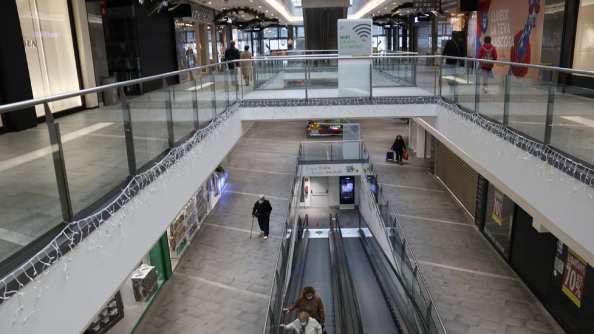 Centres comercials buits i carrers del centre plens de gent a Reus