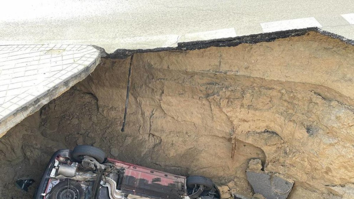 Un forat de més de tres metres d'alt s'empassa un cotxe amb el conductor dins