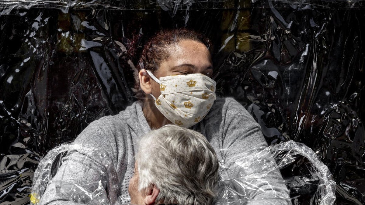Un abrazo protegido con plástico para evitar contagios de covid-19, premio World Press Photo 2021