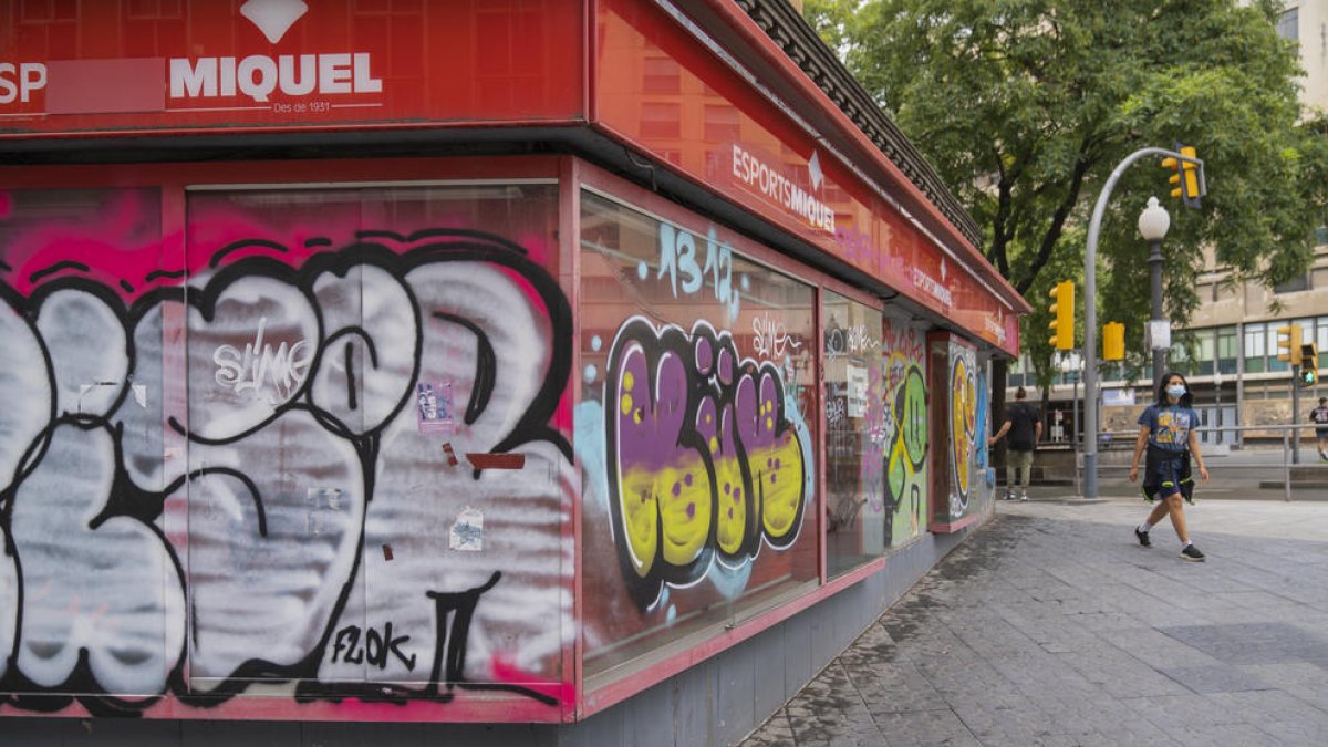 Imatge d'un local del carrer Ramon i Cajal amb la Rambla Nova amb pintades a la façana.  