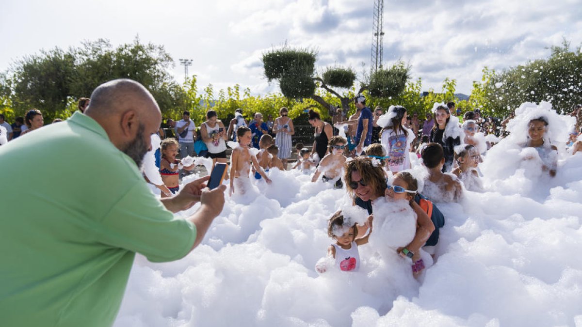Grans i petits gaudeixen amb la festa aquàtica i de l'escuma a Torredembarra