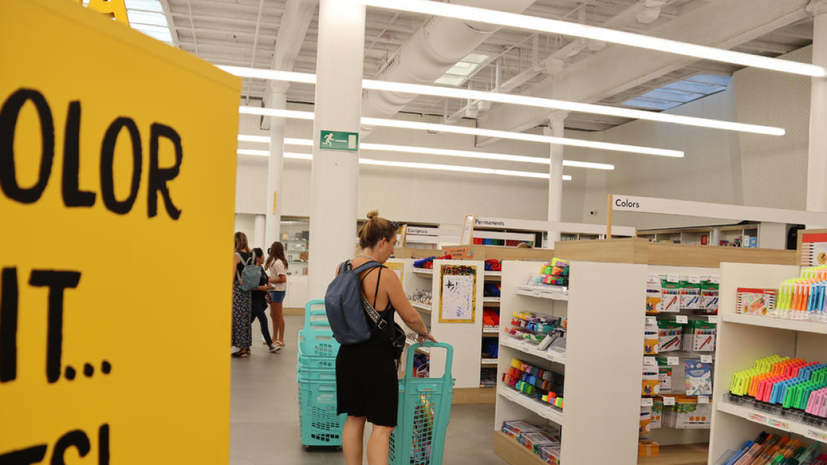 Imagen de una madre comprando material escolar.