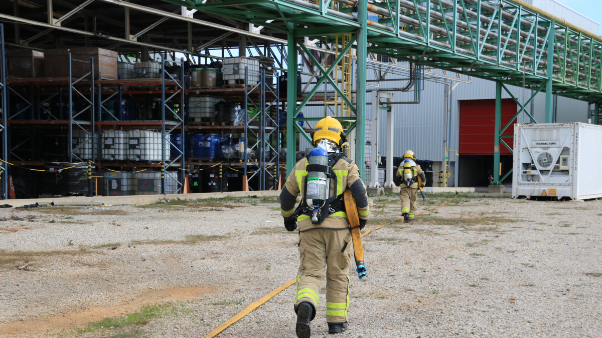 Un bombero de la Generalitat se acerca a la nave de una empresa de Constantí donde se ha realizado el simulacro de accidente de riesgo químico