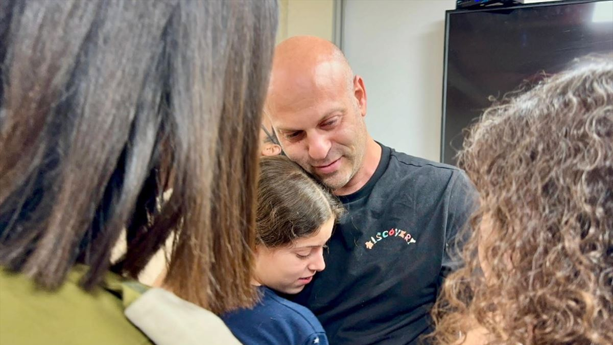 Una nena, ostatge de Hamàs, abraça el seu oncle|paio després de ser alliberada.