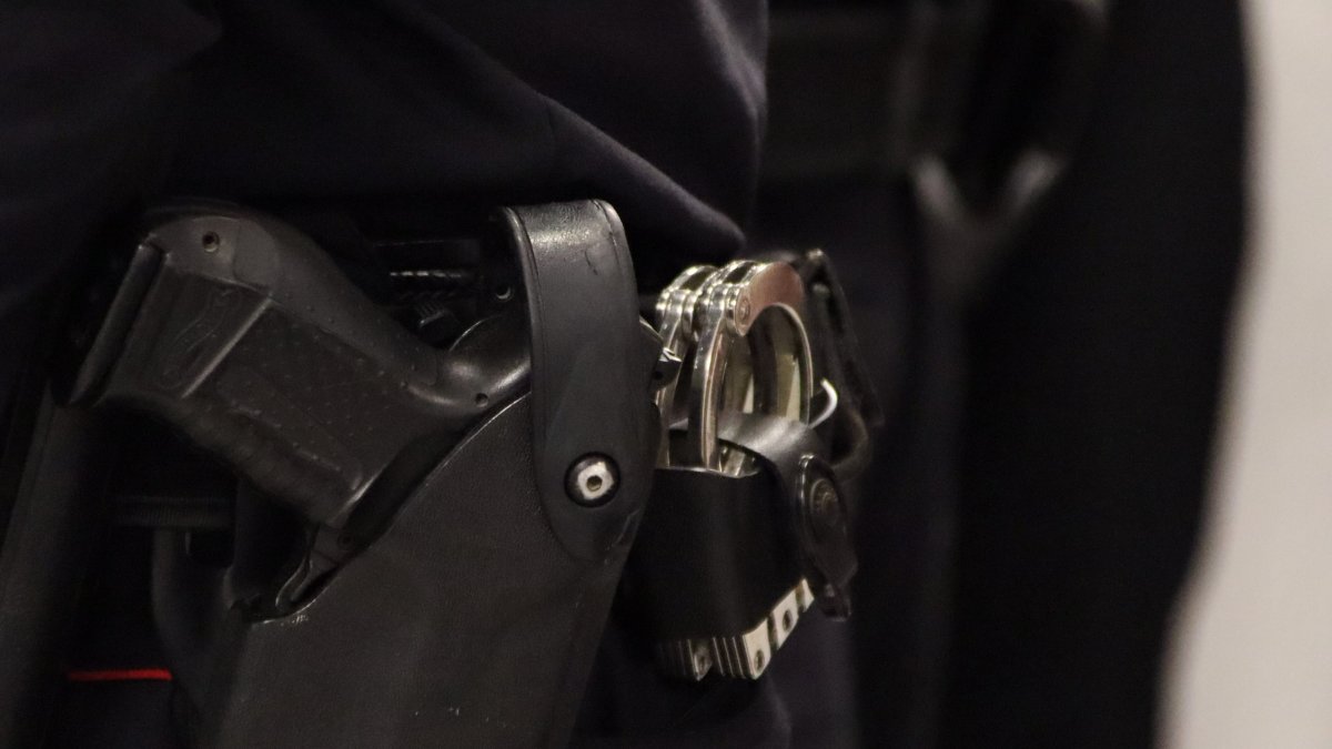 Imagen de archivo del arma y las esposas|manillas de un agente de los Mossos.