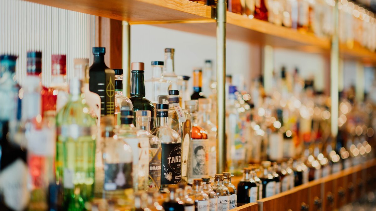 Una prestatgeria plena d'ampolles de begudes alcohòliques.