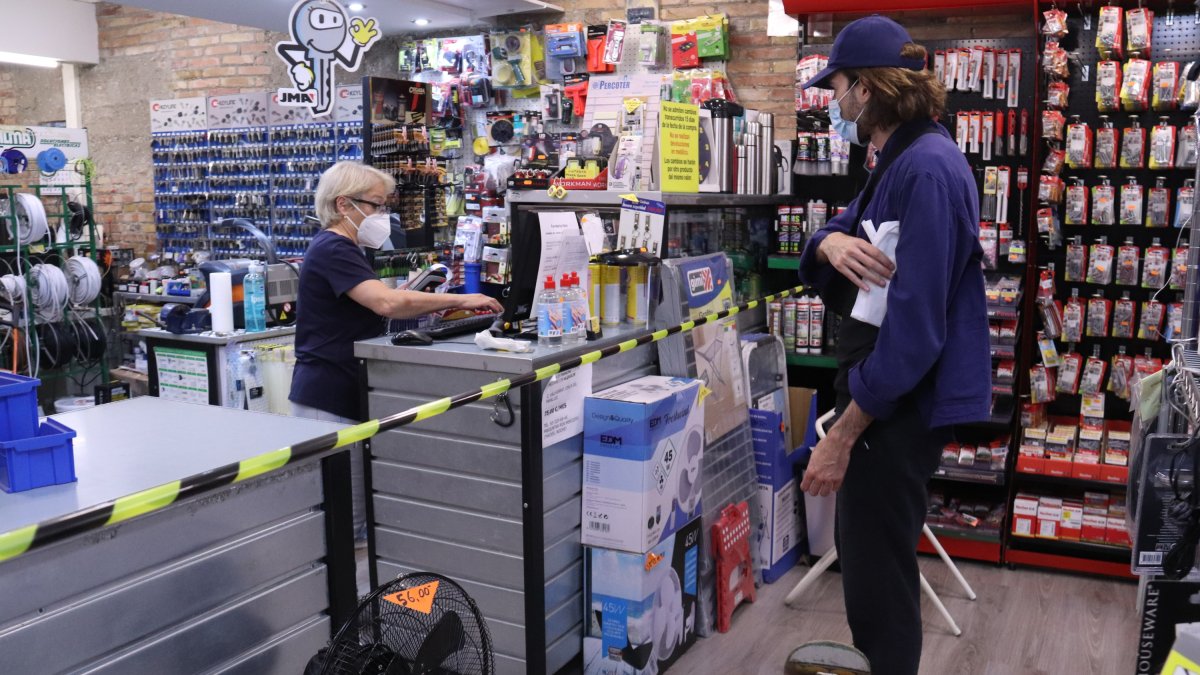 Una autònoma que regenta la Ferreteria Vera atenent un client.