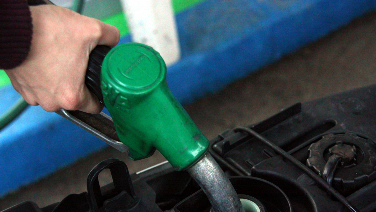 Una mànega de benzina dins el dipòsit d'una motocicleta.