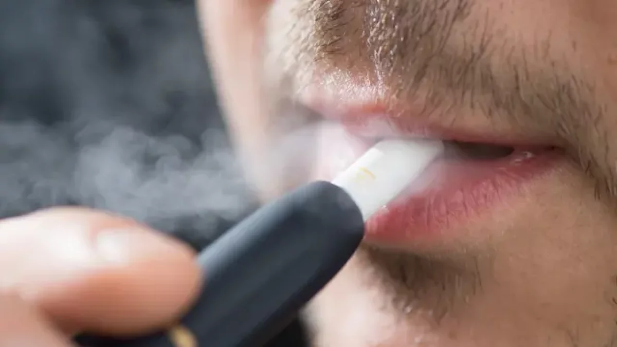Foto de archivo de un hombre fumando tabaco calentado.