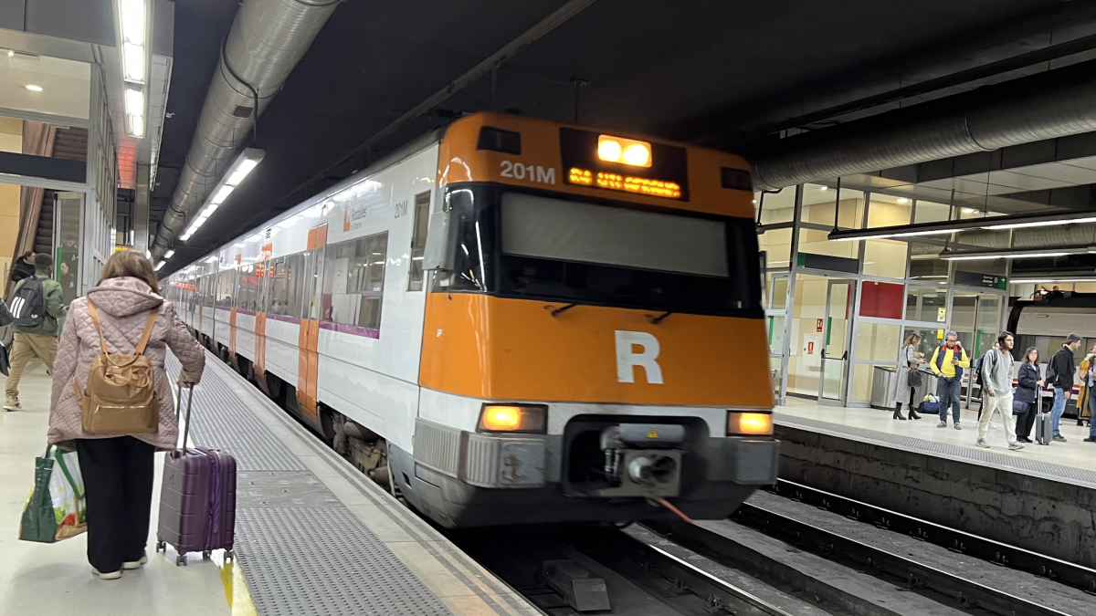 Una mujer la estación de Sants cogiendo un tren.