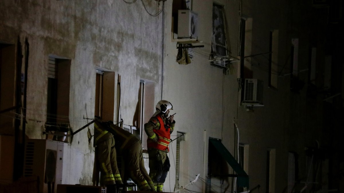 Els Bombers treballen en la recerca de restes humanes a l'edifici esfondrat al carrer Canigó de Badalona .