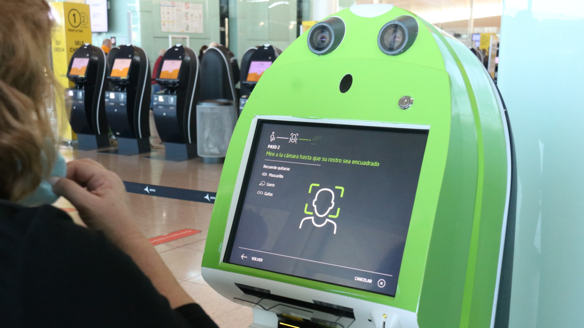 Pla escorç d'una passatgera fent el check-in mitjançant el reconeixement biomètric a l'aeroport del Prat