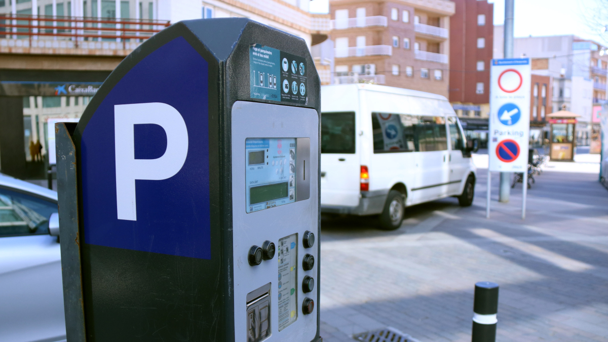 Parquímetro de zona azul ante la entrada en el aparcamiento soterrado de la plaza del Mercado de Amposta.