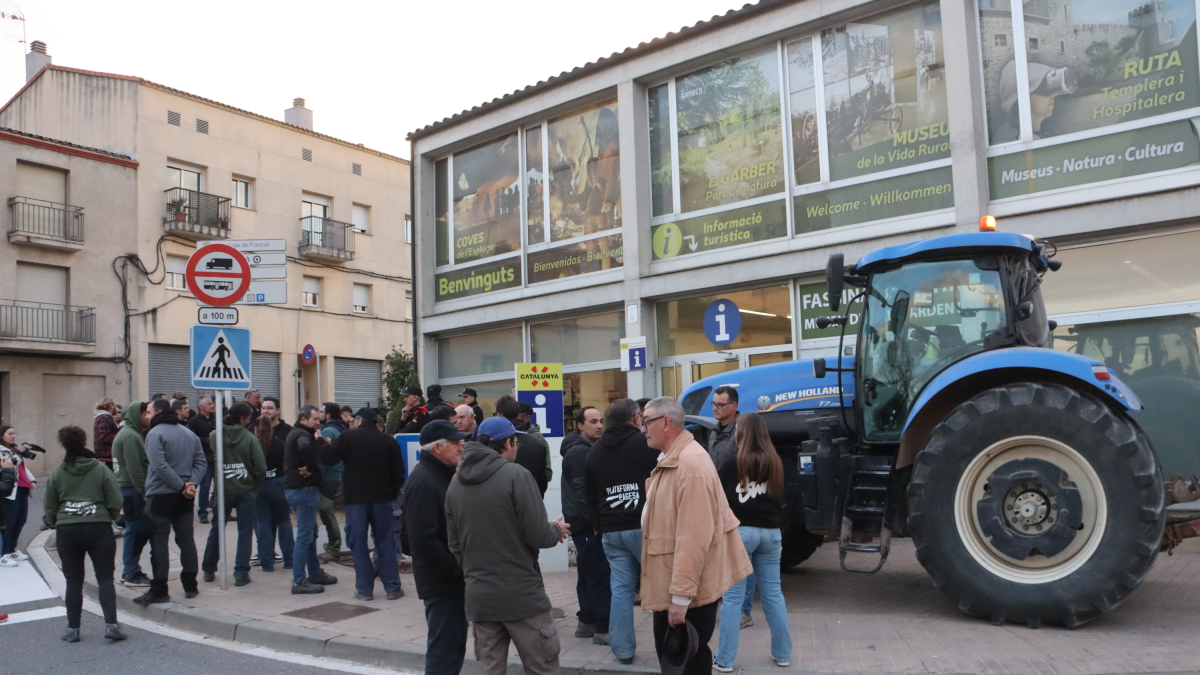 Varios payeses frente a un tractor esperan al presidente de la Generalitat, Pere Aragonès.