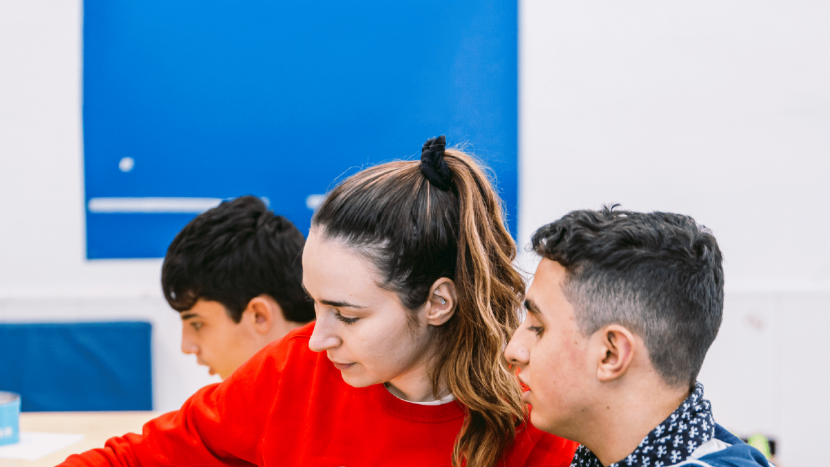 Imatge d'un alumne amb transtorn de l'espectre autista amb una professora.