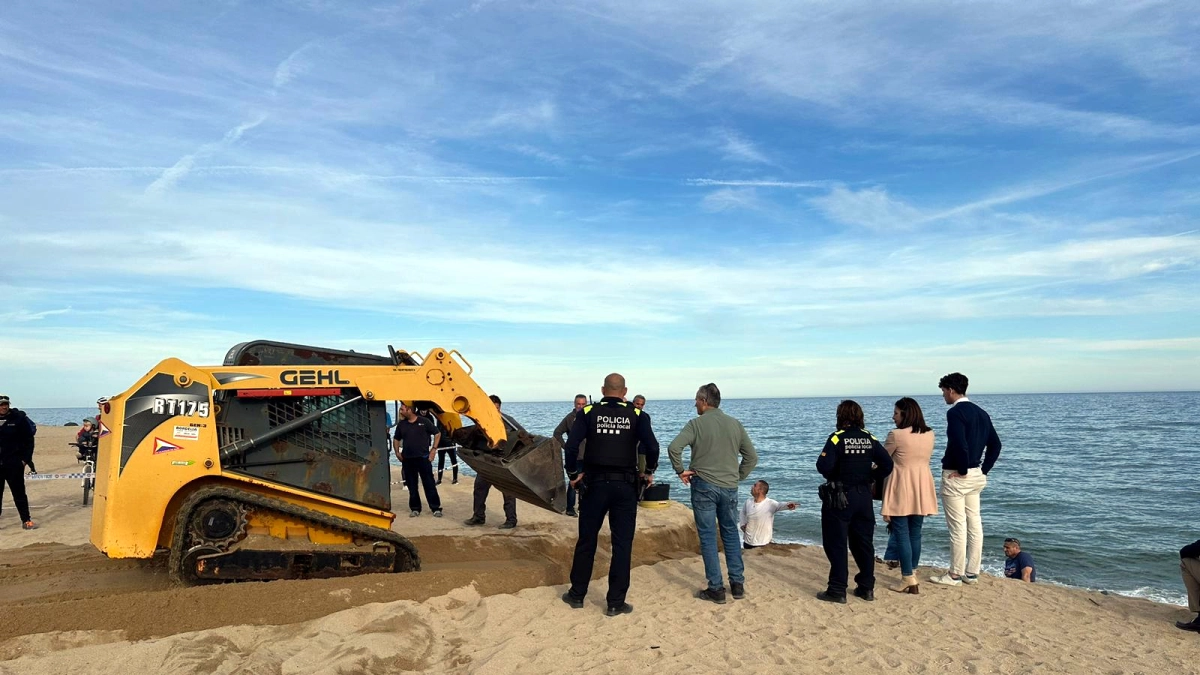 Una petita retroexcavadora mirant de recuperar totes les restes òssies a la platja de Vilassar de Mar