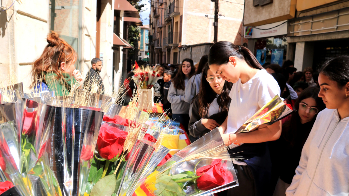 Unas chicas compran rosas en la calle Sant Blai de Tortosa.