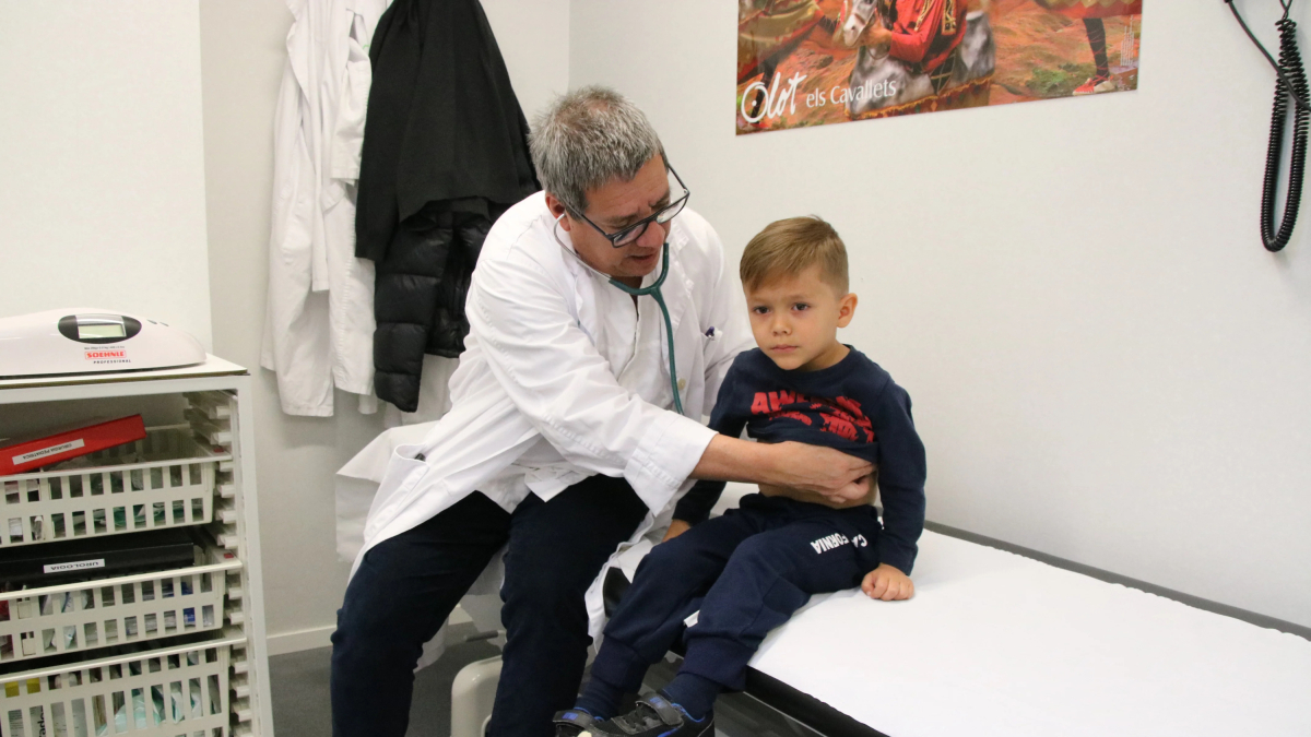 Un médico pediatra visitando a un paciente con patología respiratoria en el hospital de Olot