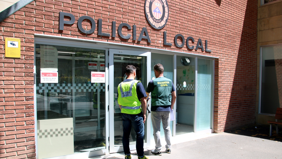 Un agente de la Guardia Civil y otro de la Policía Local de Calafell entrando a la comisaría del municipio.